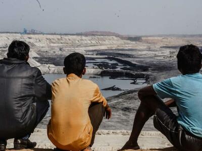 Hombres adivasis observan la inmensa mina de carbón de PEKB, que ha destruido gran parte de su tierra ancestral. Bosque de Hasdeo, Chhattisgarh. © Vijay Ramamurthy