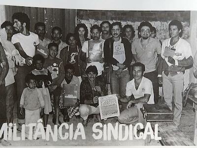 En el camino, cuando regresaban del 1º Congreso de la CUT, realizado en San Bernardo do Campo, en 1983. Su Pedro Xapuri está agachado bien al centro (sosteniendo el periódico) y el Chico Mendes está de pie atrás.