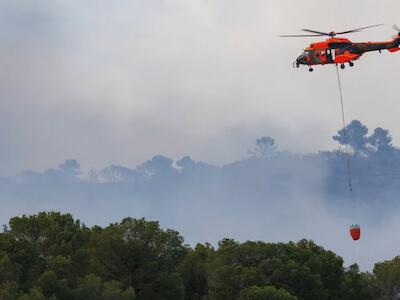 Un helicóptero colabora en las tareas de extición en el incendio que se declaró en el Parque Natural del Carrascal de la Font Roja (Alicante, España) en julio de 2025. Didaccc/Shutterstock