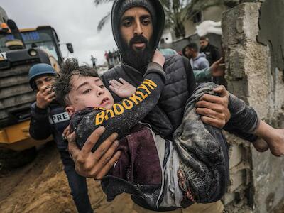 Un hombre lleva a un niño herido y rescatado debajo de los escombros de su casa familiar, tras un ataque aéreo israelí contra Deir Al Balah, en el sur de la Franja de Gaza, el 7 de marzo de 2024. MOHAMMED SABER (EFE)