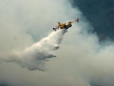 © Unsplash/Chiara Guercio Un avión de extinción de incendios arroja agua sobre un incendio forestal.