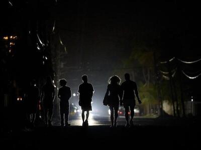 Los cubanos caminan en la oscuridad durante el apagón en La Habana.