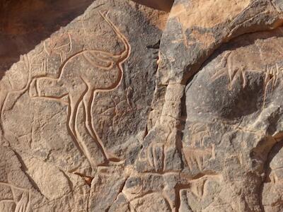 Grabados rupestres de principios del Holoceno muestran figuras humanas y grandes animales que habitaron el Sahara cuando la región tenía vegetación y un clima muy distinto al actual.Werner Forman/Getty Images