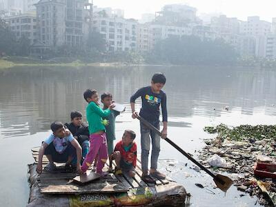 © UNICEF/Jannatul Mawa Niños cruzando un lago contaminado en una balsa casera en Dhaka, Bangladesh.