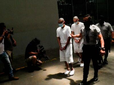 Un acusado de pertenecer a las pandillas es trasladado a una celda del Centro de Confinamiento del Terrorismo, en el centro de El Salvador, durante una de las pocas visitas de la prensa a esa cárcel de máxima seguridad. Imputados como él esperan varios años para que se realice una audiencia colectiva para ser juzgado. Imagen: Edgardo Ayala / IPS