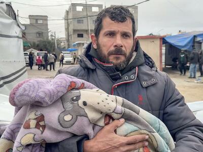 Maher Bassiouni carga el cuerpo de su hijo Mohammed, de un año, tras morir de frío en Deir al-Balah. 13 de enero de 2026 (Captura de pantalla proporcionada por Abdel Qader Sabbah).