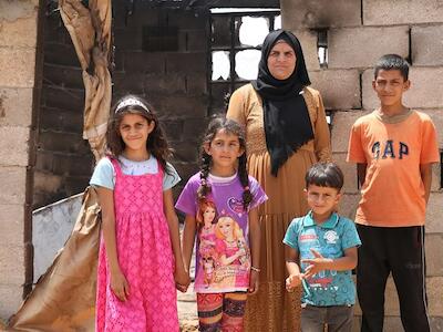 UNICEF/Media Clinic Una familia palestina frente a su casa en el sur de Hebrón, en Cisjordania, que fue incendiada en un ataque perpetrado por colonos.