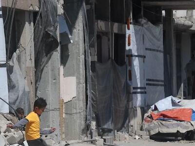 Noticias de la ONU Niños jugando al fútbol entre los escombros en la ciudad de Gaza.