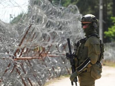 Un guardia fronterizo polaco permanece junto a una alambrada en la frontera entre Polonia y Bielorrusia, en Polowce, Polonia, el 21 de julio de 2025. © 2025 AP Photo/Czarek Sokolowski