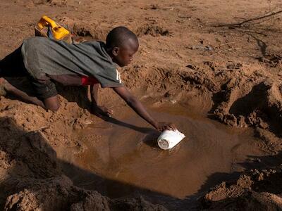 Un niño busca agua en los depósitos que quedan de un río seco en Somalia. Foto: UNICEF/Sebastian Rich