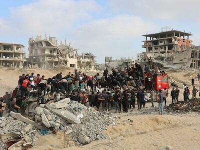 Civiles palestinos corren hacia un camión con ayuda humanitaria que circula por la calle Al-Rashid, en el oeste de Jabalia, el 22 de junio de 2025, después de que algunos camiones entraran en el norte de la Franja de Gaza. (Foto de Omar AL-QATTAA / AFP)