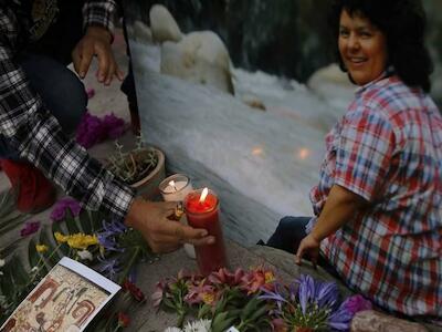 Un hombre coloca una vela encendida junto a una imagen de la activista ambiental y de derechos indigenas Berta Caceres en una ceremonia espiritual, un da antes de un juicio contra uno de los presuntos autores intelectuales del asesinato de Caceres, en Tegucigalpa, Honduras, el lunes 5 de abril de 2021. (Foto AP/Elmer Martnez) (Copyright 2021 The Associated Press. All rights reserved)