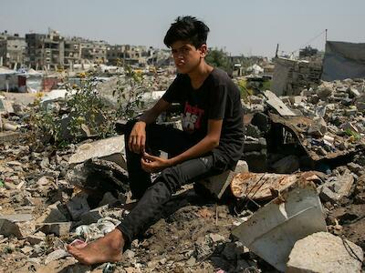 Foto: UNICEF/Mohammed Nateel. Un joven sentado sobre las ruinas de la que fue una casa en Gaza.