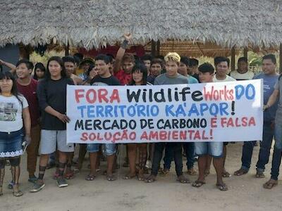 “¡Fuera Wildlife Works del territorio Ka'apor! ¡El mercado de carbono es una falsa solución ambiental!” se lee en la pancarta que sostienen jóvenes Ka’apor.